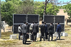 「垂直両面受光パネル前で説明を受ける委員」の画像