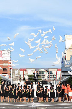 「子どもたちがハト型風船を大空へ」の画像